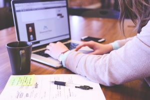 person using laptop with coffee